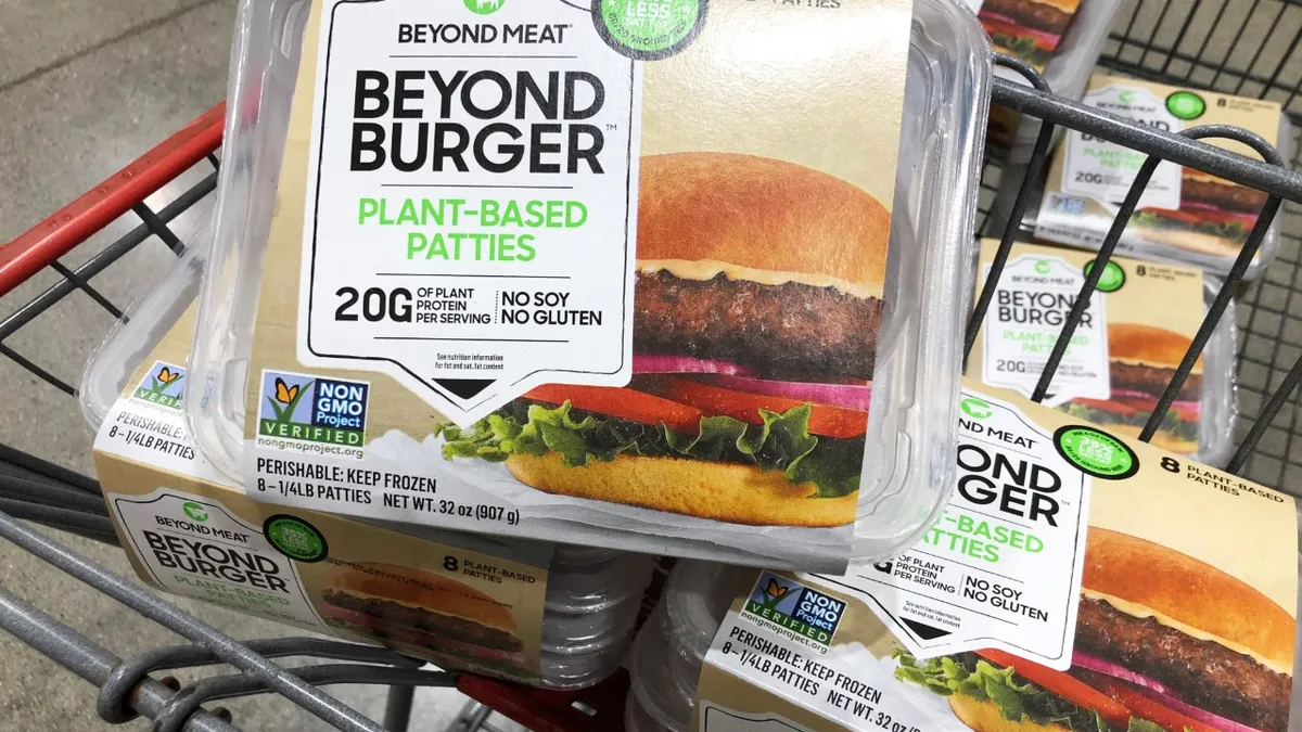 A large package of Beyond Meat burgers sits in a shopping cart.