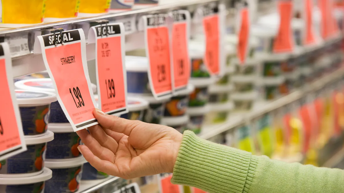 Hand reaching out to "Special" pricing tag in a grocery store.